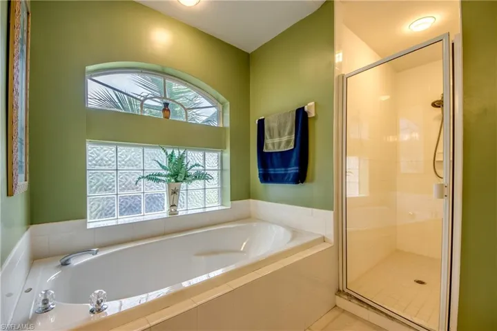 Bathroom with a healthy amount of sunlight, shower with separate bathtub for all your needs.
