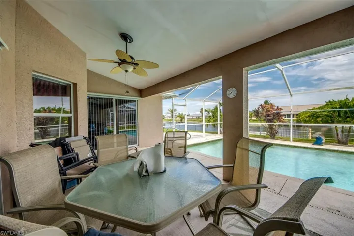 Lanai with plenty of room to dine poolside with ceiling fan and vaulted ceiling. Beautiful view of the peaceful canal.
