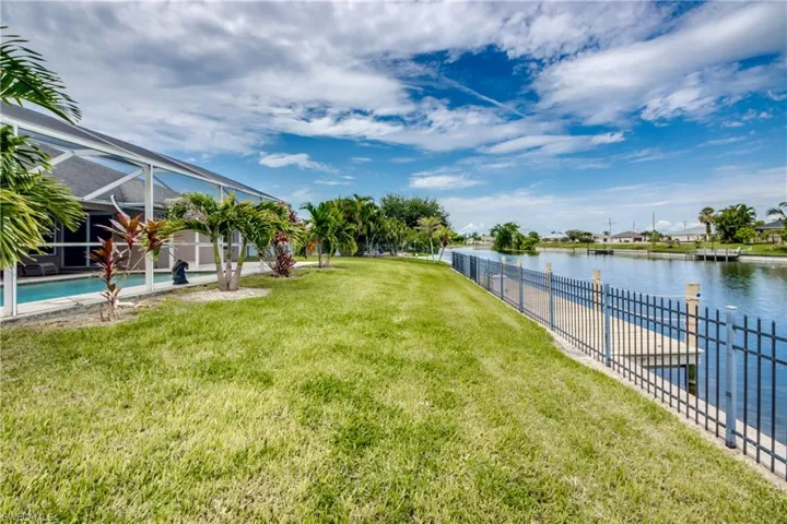 Another view of back yard featuring the water view, and mature landscaping.