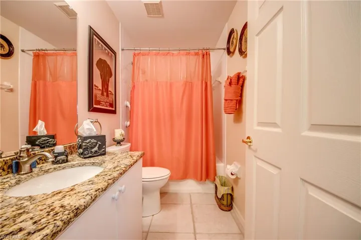 Full guest bathroom featuring vanity, toilet, shower / bathtub combination with curtain.