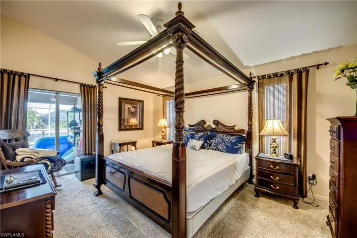 Carpeted primary bedroom with a new Select Comfort mattress offers access to outside, lofted ceiling, and ceiling fan