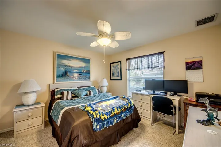Carpeted guest bedroom featuring ceiling fan and built in closet.