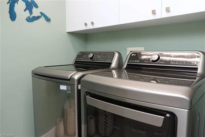 Washroom featuring cabinet space and washer and dryer