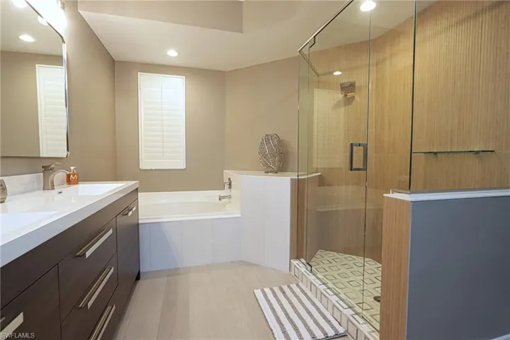 Full bathroom with a garden tub, a stall shower, vanity, and recessed lighting