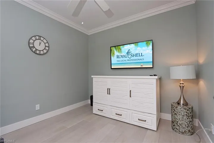 Bedroom with crown molding, baseboards, a ceiling fan, and light wood finished floors