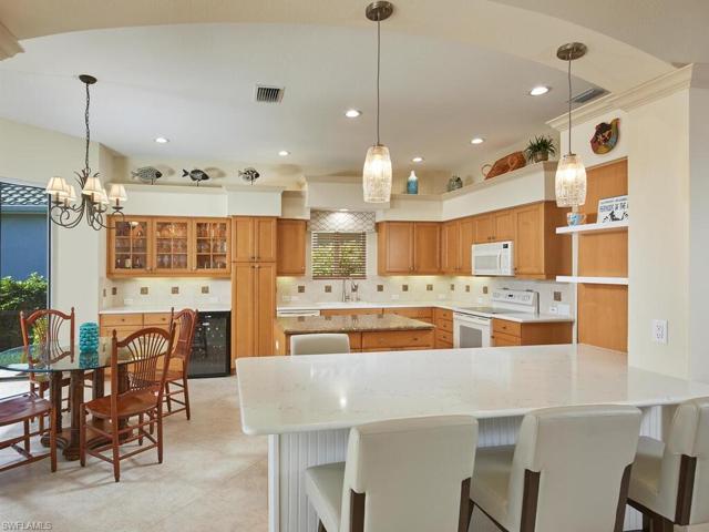 Significant renovation...column was removed and counter height lowered for optimum visibility between kitchen and great room. Counter with bar stools on each side is quartz. Note new pendant light fixtures above.