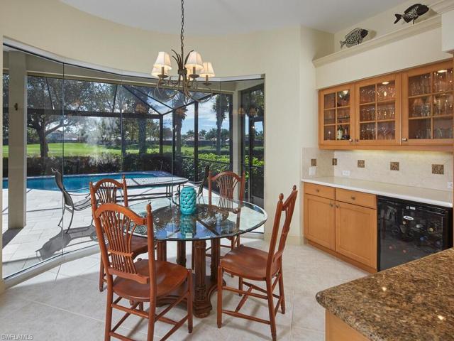 Kitchen morning room with upgraded mitered glass windows starting at floor level and soaring above for grand view of lanai, pool and fairway #4 of south course. Note wine cooler to right.