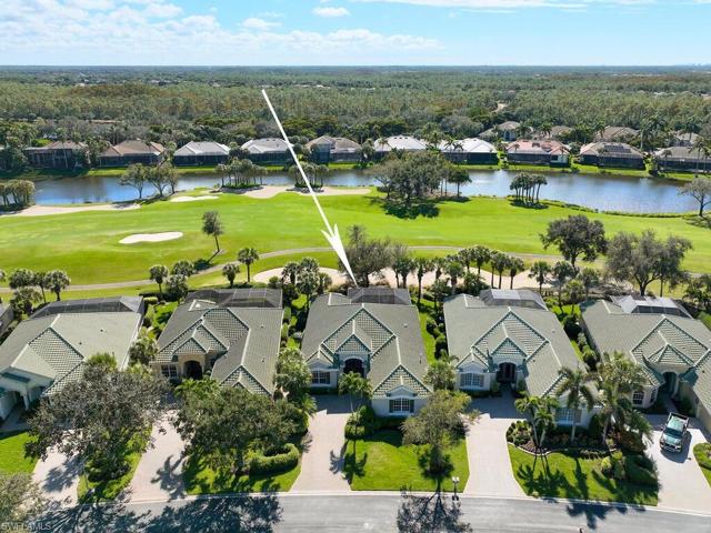 Aerial view of house with fairway and lake beyond