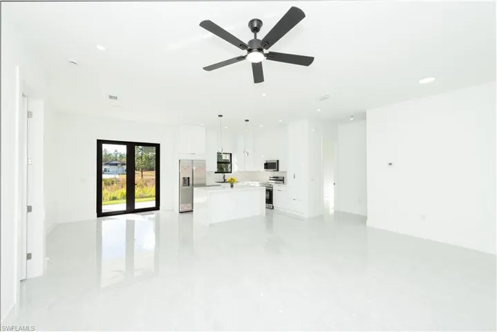 Unfurnished living room featuring recessed lighting, ceiling fan, and light marble finish flooring