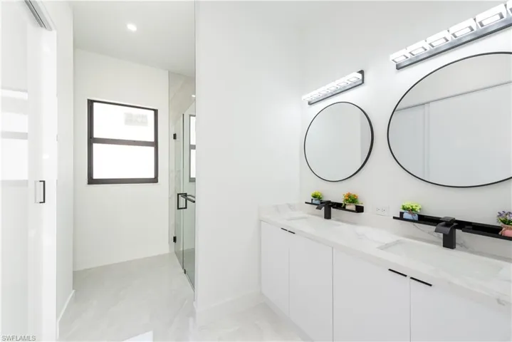 Full bath with a stall shower, double vanity, and recessed lighting