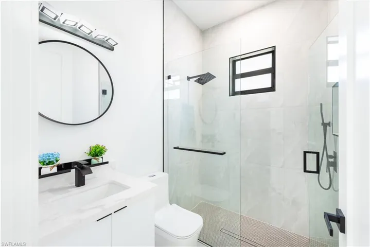 Full bath featuring a shower stall and vanity