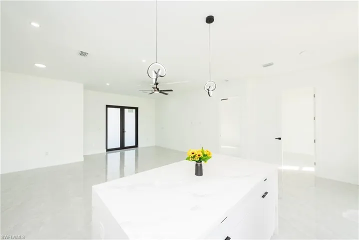 Kitchen featuring hanging light fixtures, white cabinets, recessed lighting, a center island, and open floor plan