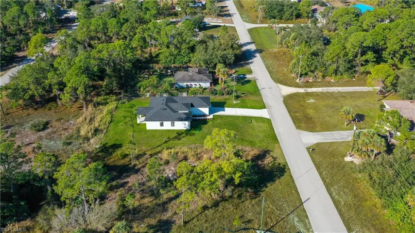 Aerial view of property's location featuring a tree filled landscape