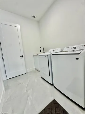 Laundry room featuring separate washer and dryer and cabinet space