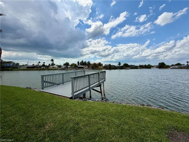 Private dock with a composite deck surface and wood railings, offering direct water access