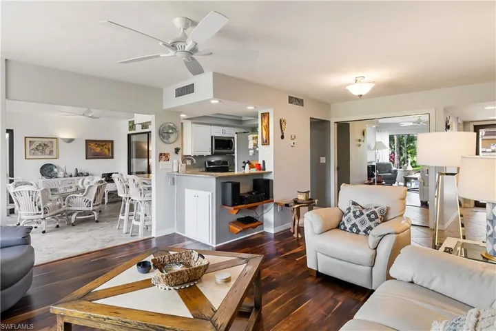 Living room with ceiling fan and dark hardwood / wood-style floors