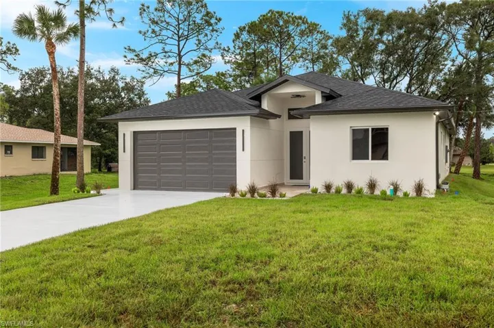View of front of property featuring a garage and a front yard