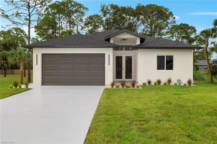 View of front of home featuring a garage and a front lawn