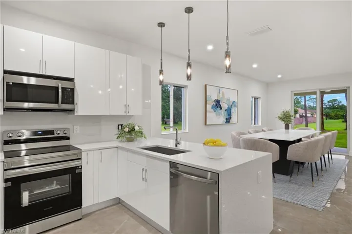 Kitchen with white cabinets, stainless steel appliances, sink, and kitchen peninsula