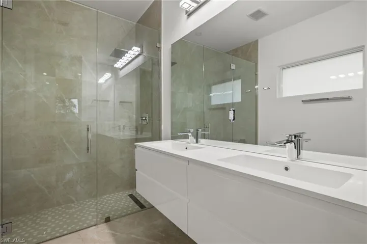 Bathroom featuring an enclosed shower, tile patterned flooring, and vanity