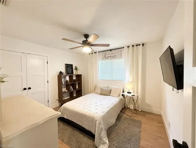 Bedroom featuring a ceiling fan, light wood finished floors, and a closet