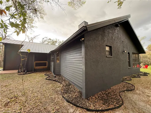 View of side of property featuring stucco siding and a chimney