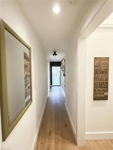 Hallway with light wood finished floors and baseboards
