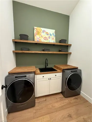 Laundry room featuring cabinet space and light wood-style flooring