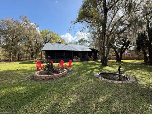 View of yard with a fire pit, a sunroom, and a patio area