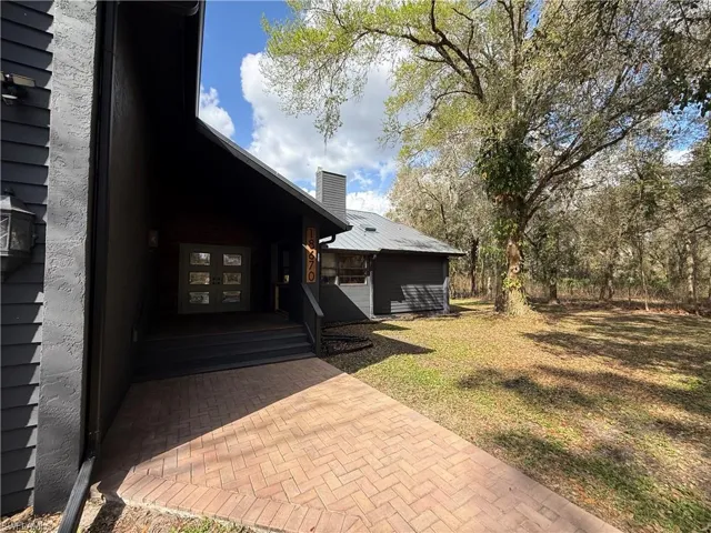 View of side of home featuring a yard and a chimney