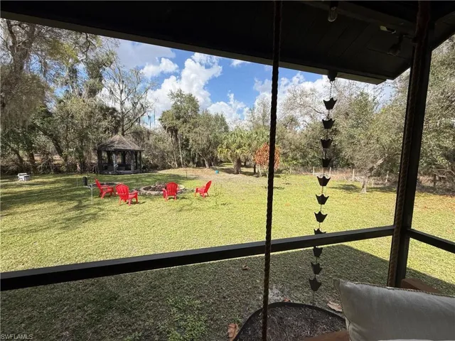 Surrounding community with a gazebo and view of wooded area