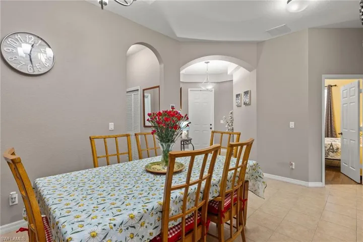 Tiled dining room with a raised ceiling