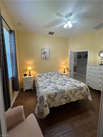 Bedroom with ceiling fan and dark hardwood / wood-style floors