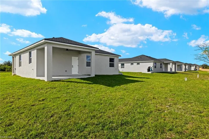 Rear view of house with a yard, a patio, and ceiling fan