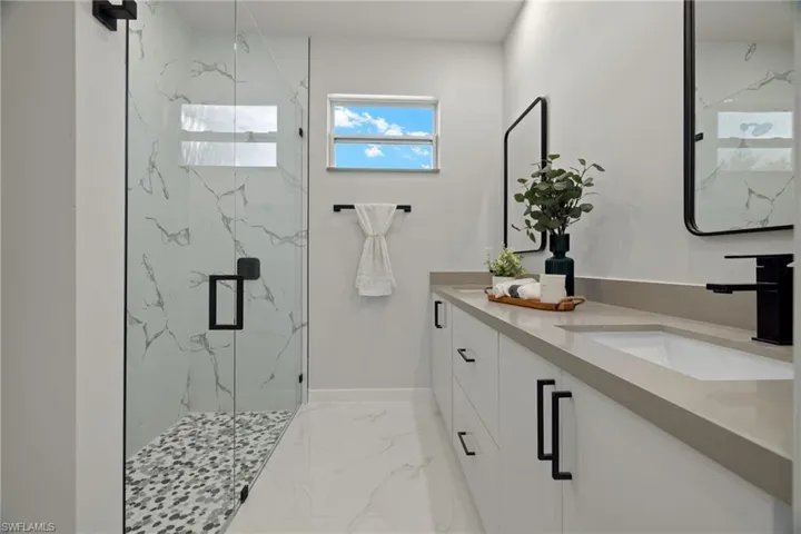 Bathroom featuring vanity and a shower with shower door
