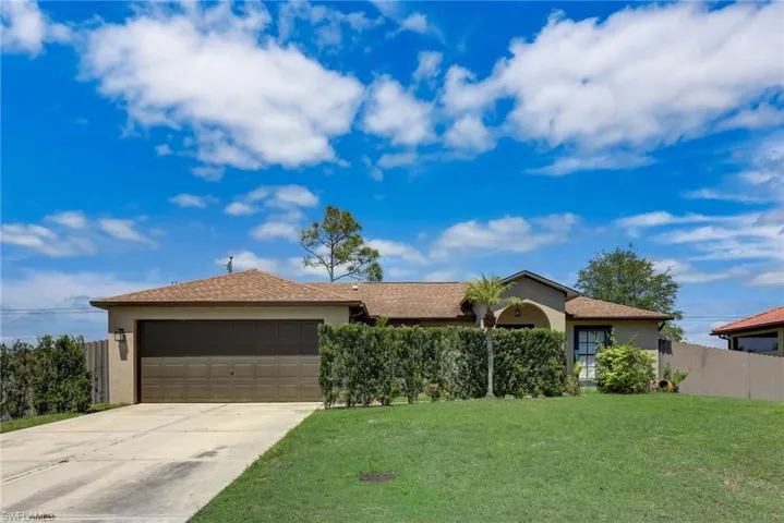 Single-story residence featuring a brown shingle roof, attached garage, and stucco exterior