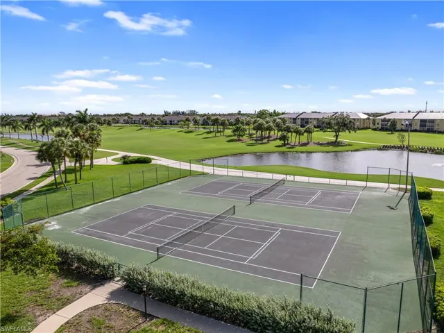 View of sport court with a water view and fence