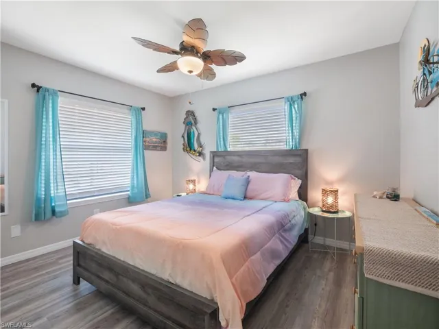 Bedroom with baseboards, wood finished floors, and a ceiling fan