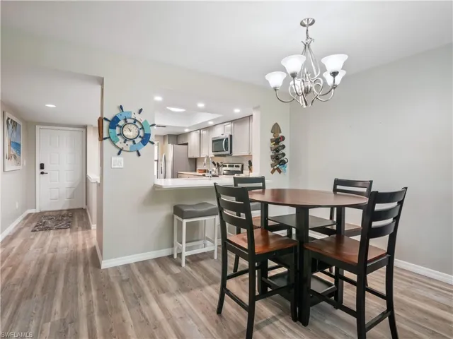 Dining space with light wood-style flooring, baseboards, a chandelier, and recessed lighting