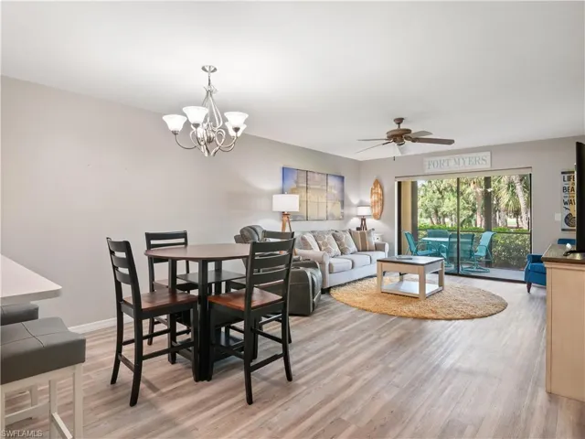 Dining space featuring baseboards, light wood-style flooring, and ceiling fan with notable chandelier