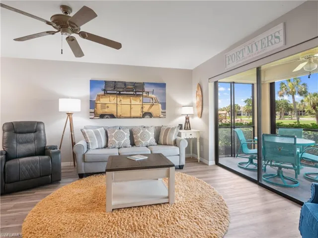 Living area featuring baseboards, wood finished floors, and a ceiling fan