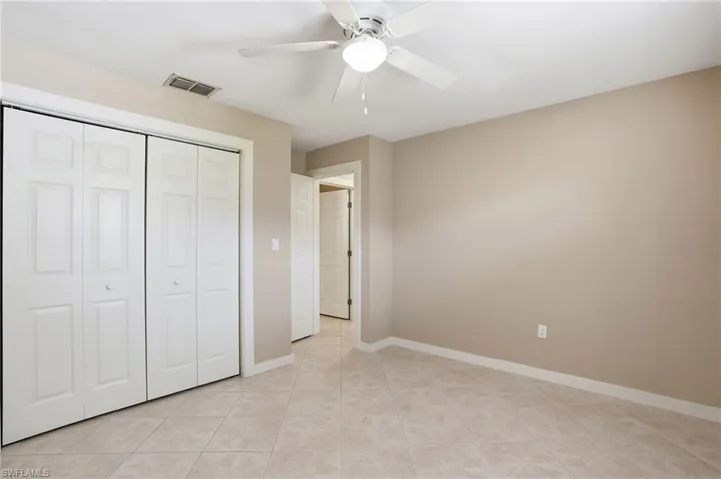 Unfurnished bedroom with a ceiling fan, a closet, and light tile patterned floors