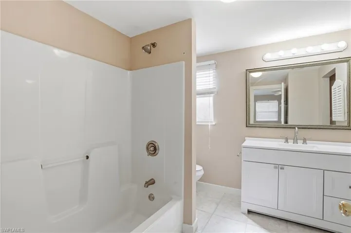 Bathroom with vanity,  shower combination, and light tile patterned floors