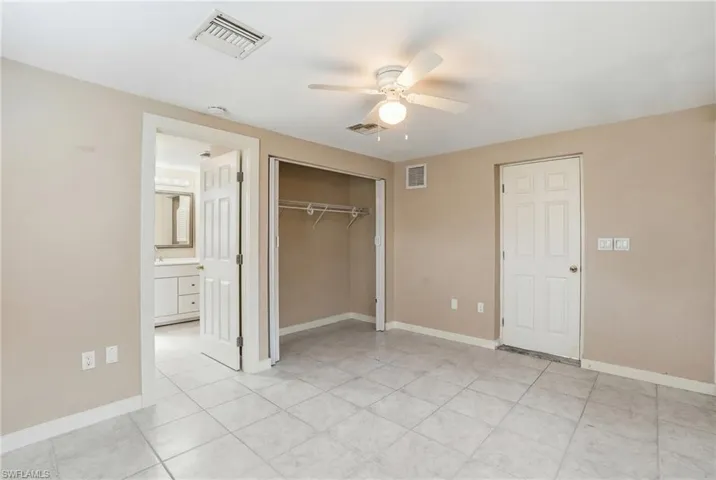 Unfurnished bedroom with ceiling fan, a closet, and light tile patterned floors