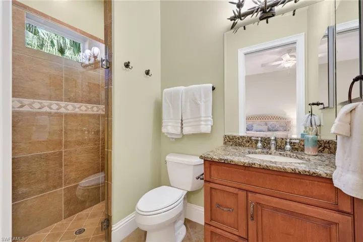 Full bath with a stall shower, vanity, ensuite bath, and ceiling fan