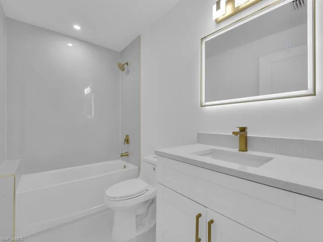 Full bathroom featuring tile patterned floors, vanity, tiled shower / bath combo, and toilet