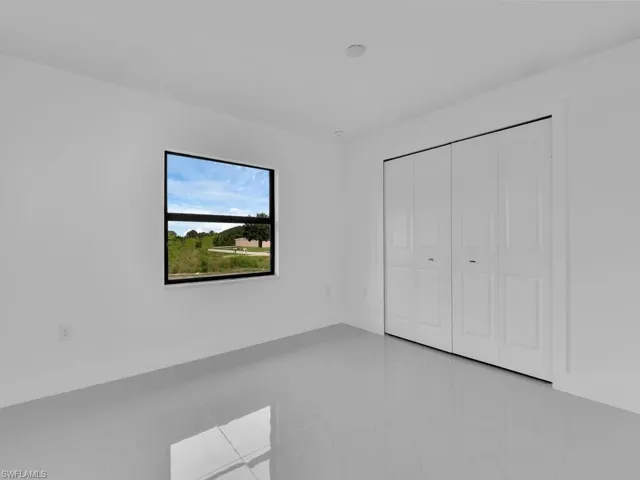 Unfurnished bedroom featuring tile patterned flooring and a closet