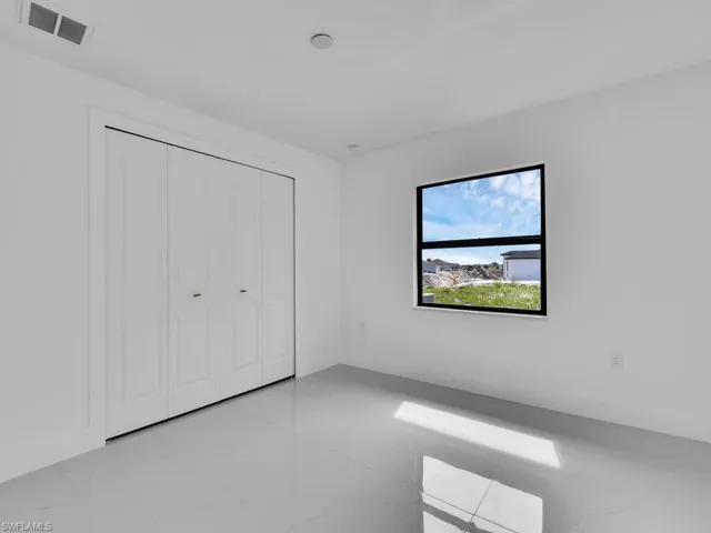 Unfurnished bedroom with light tile patterned flooring and a closet