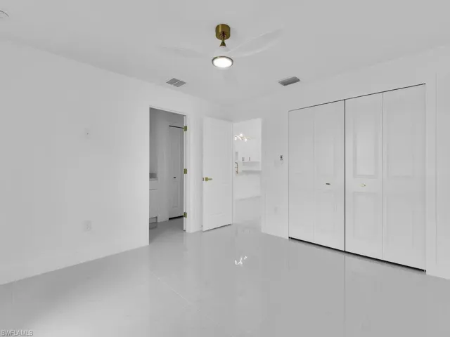 Unfurnished bedroom with light tile patterned flooring, ceiling fan, and a closet