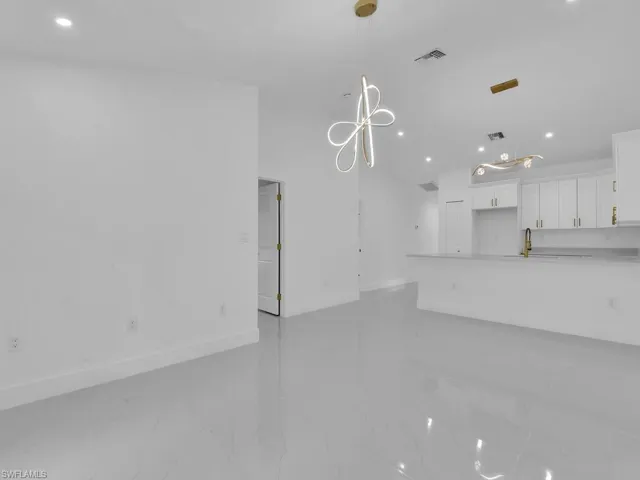 Unfurnished living room with sink and light tile patterned floors